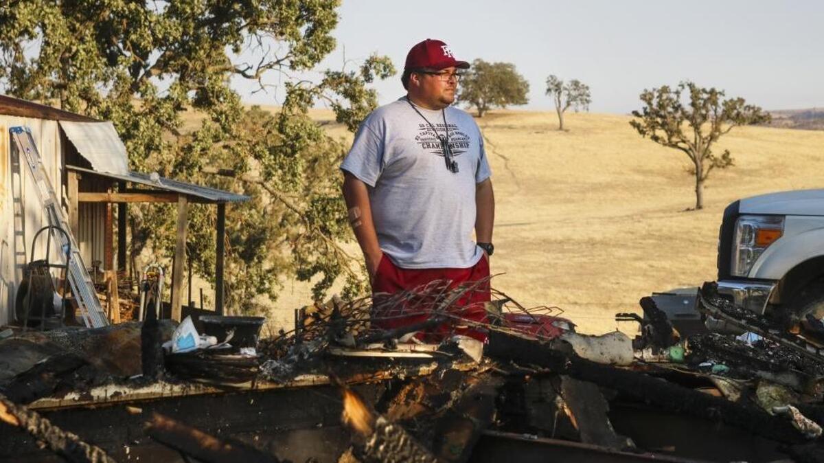 Paso Robles High School football coach Matt Carroll looks over the burned remains of his family's home in Paso Robles. Photo by Travis Gibson 08-18-16