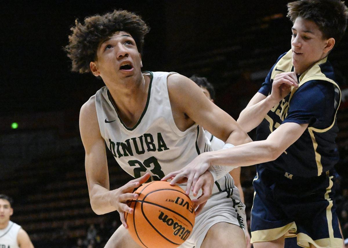 Mission Prep’s Brody Miller, right, gets a hand on Dinuba’s Brice Warley, left, and in the Division II Boys game Friday, Feb. 23, 2024 in Fresno..