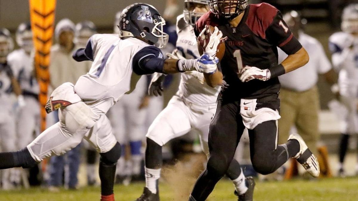Nipomo High School loses to Linfield Christian High School, 35-14, in a play-off game, Saturday, November 28, 2015. Nipomo quarterback Gavin Hall’s arm is grabbed by Linfield Christian’s Simeon Burns (1), but he manages to avoid a sack during 1st quarter paly.