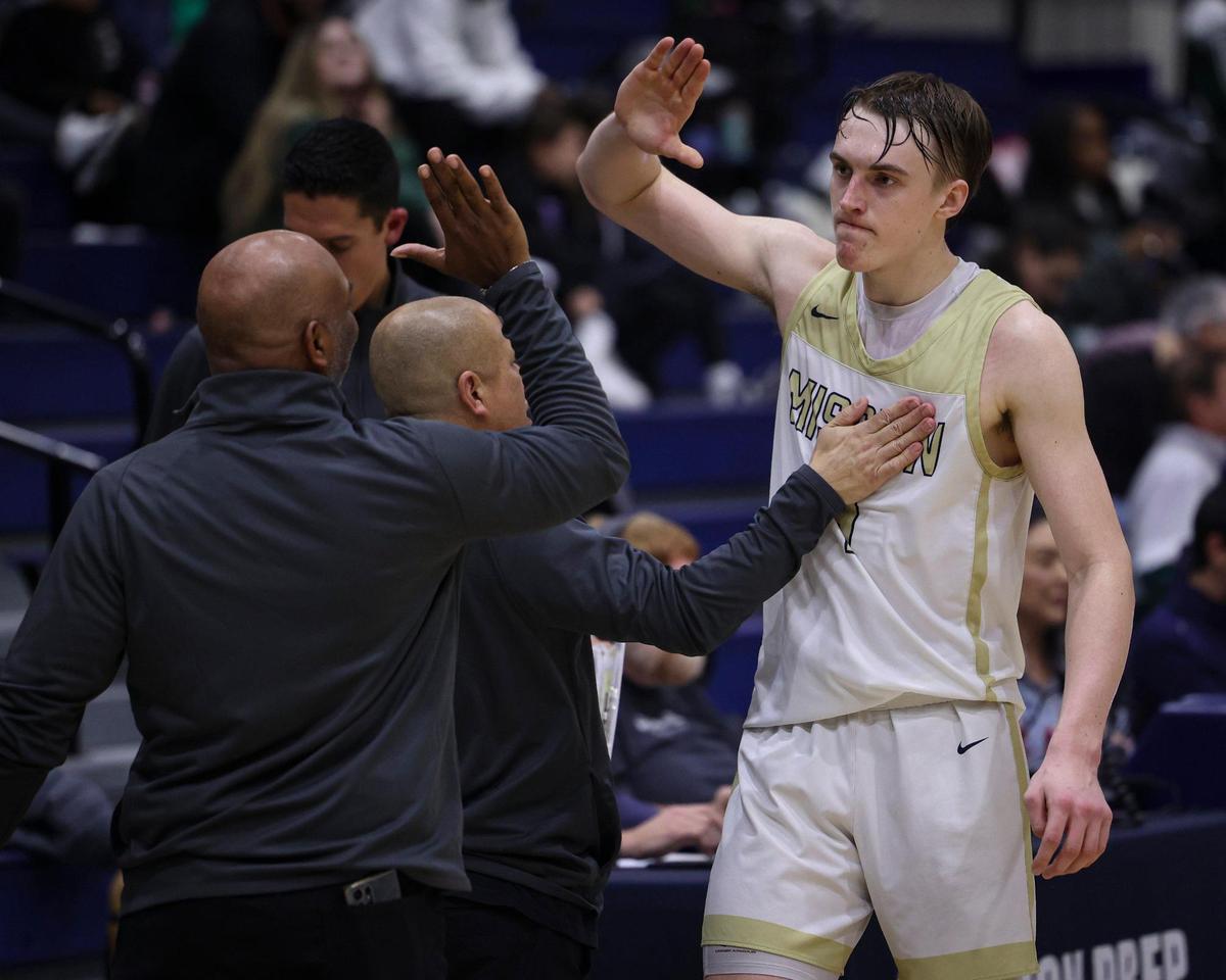 Luke Jacobson gives high fives to coaches as he comes off court late in the game. Mission Prep overcame a first half deficit to finish with a win over Hoover of Fresno, 67-56 in a high school basketball playoff Feb. 20, 2024.