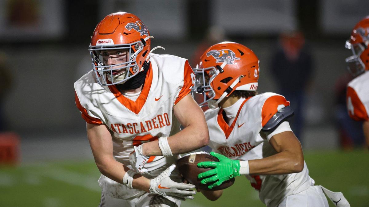Bishop Resco fakes taking the ball from Josiah Gaona as San Luis Obispo beat Atascadero 35-0 to win the Sunset League title in a high school football game on Nov. 1, 2024.