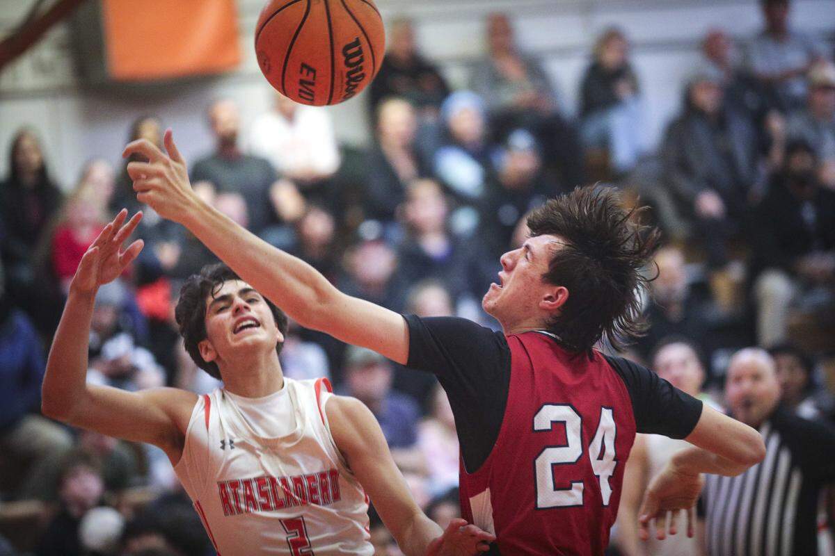 Isaiah Rodriguez, left, and Jake Gartner fight for control of rebound. Atascadero beat Sanger 82-41 in a basketball playoff Feb. 17, 2026.
