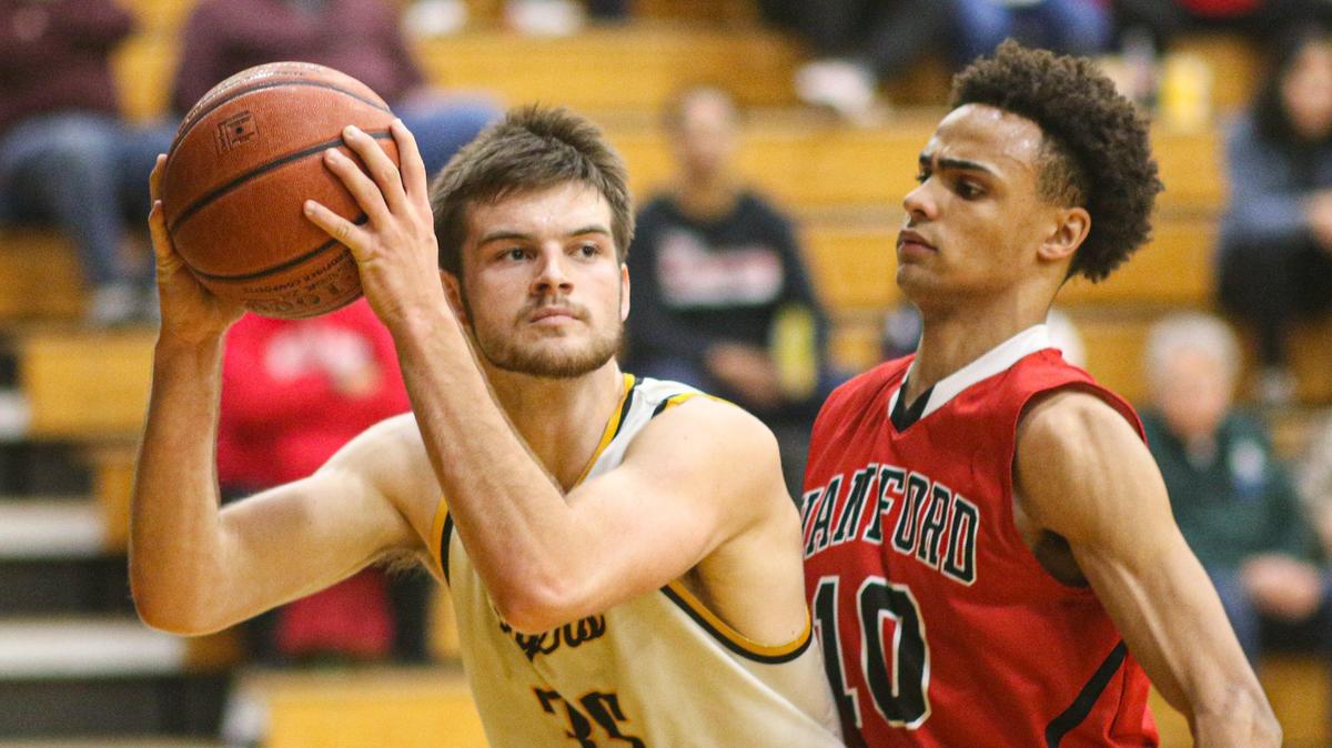 Carson Leedom looks for an open man as Juaron Watts-Brown defends. San Luis Obispo hosted Hanford in playoff basketball. The Tigers won 60-44.