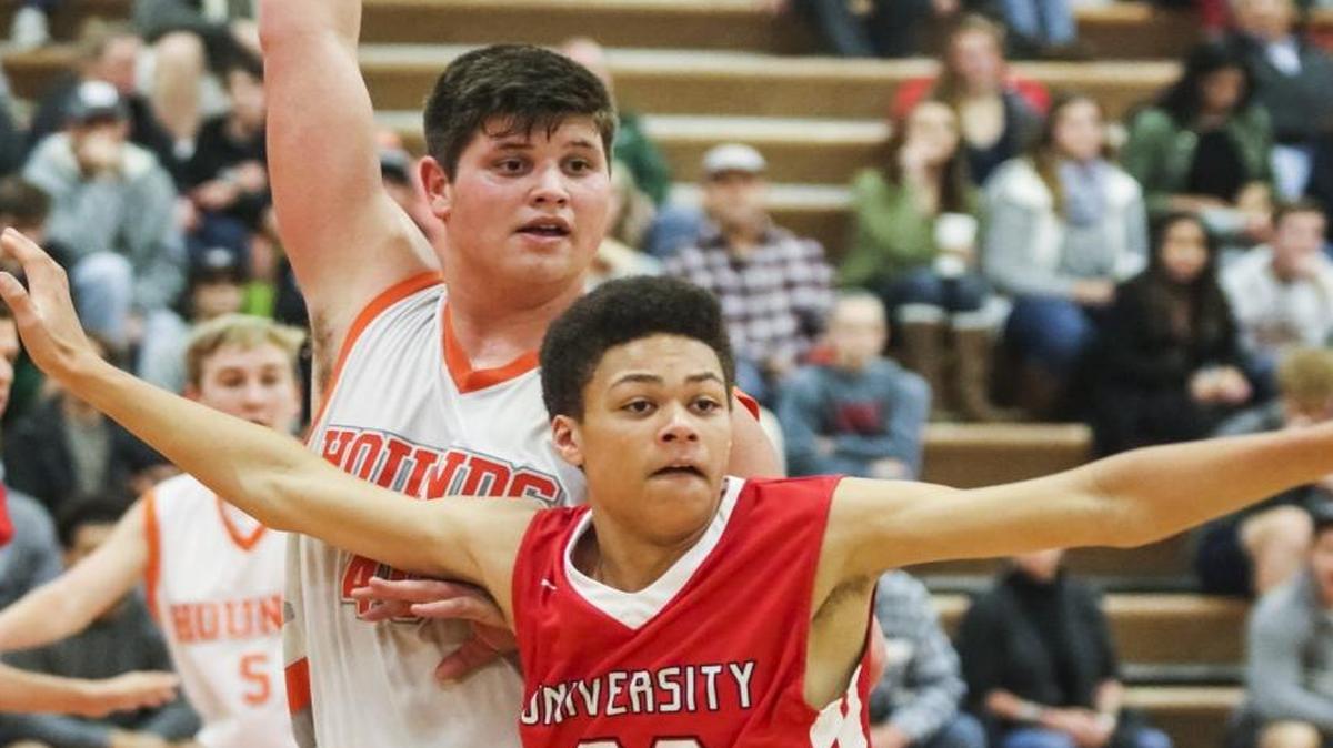Atascadero junior Kyler Warren (white) posts up against University’s Charley Moore during the Atascadero Christmas Tournament.
