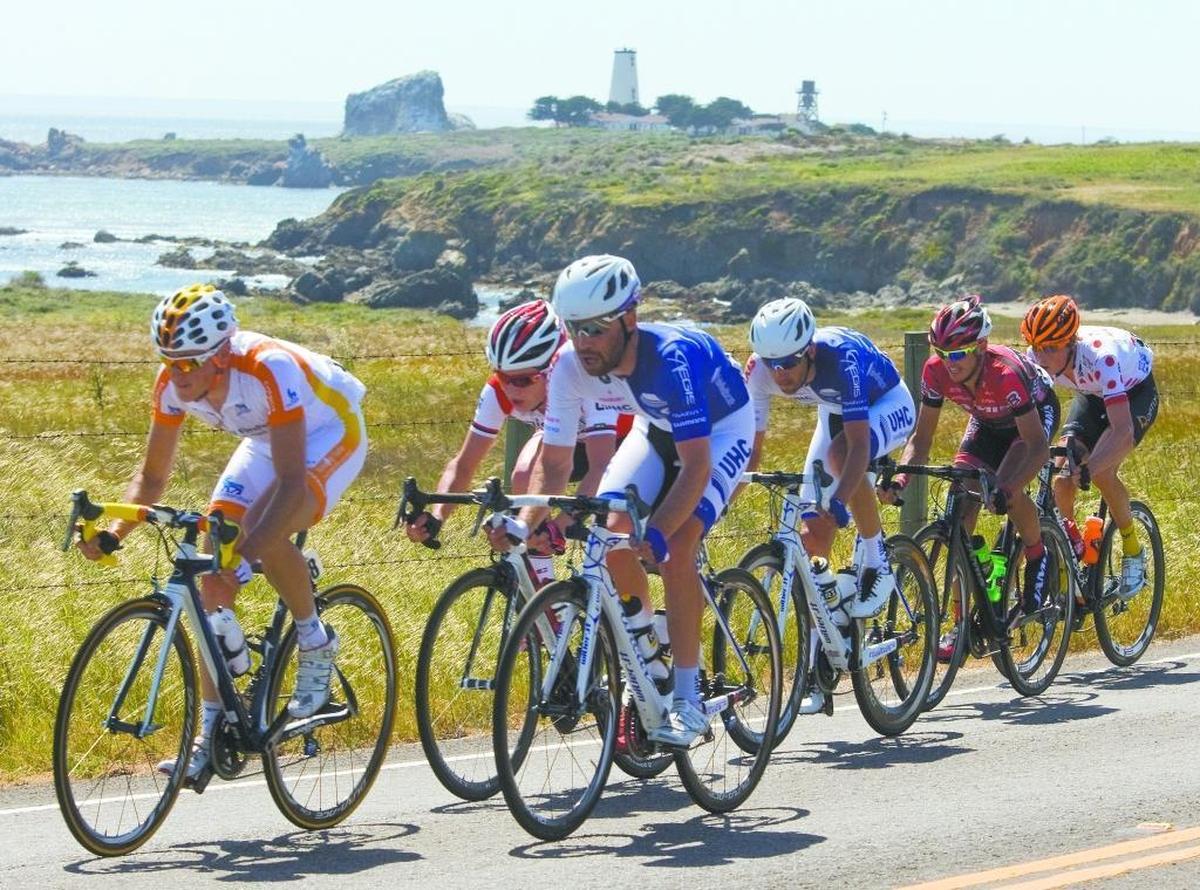 Tour of California cyclists race along Highway 1 past the Piedras Blancas Light Station in 2017. The highway was named one of the four best road trips in California by worldatlas.com.