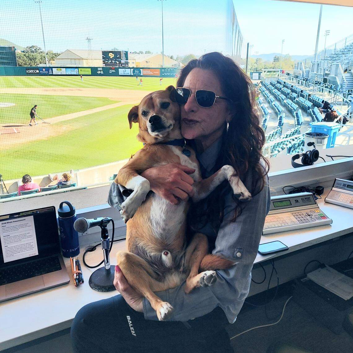 C.J. Silas with her dog, Mister Robinson, at Cal Poly baseball.