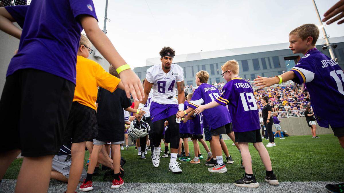 Josh Oliver, a former Paso Robles High and San Jose State football star, now plays with the Minnesota Vikings. Oliver greets kids here on Aug. 8, 2023, at a training camp practice held in Eagan, Minnesota.