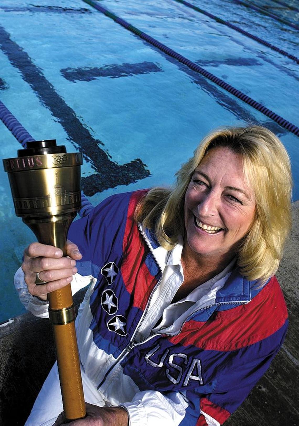 Sharon Stouder holds a torch she carried for the 1984 Olympics. Stouder won three gold medals and one silver medal for swimming during the 1964 Olympics at the age of 15.