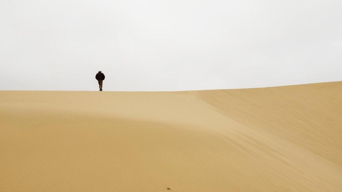 Michael Brady with the U.S. Fish and Wildlife Service walks across the top of a dune at the Guadalupe-Nipomo Dunes Wildlife Refuge.