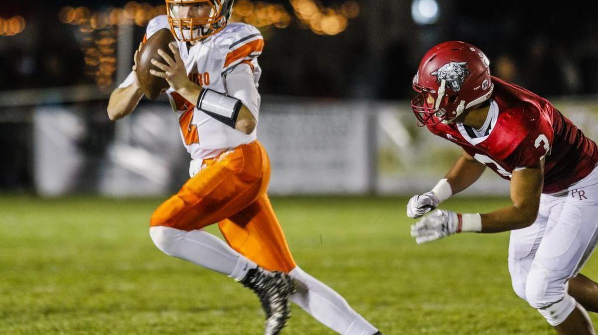 Atascadero High quarterback Carson Rinkenberger eludes a Paso Robles defender in the regular season finale on Nov. 6.