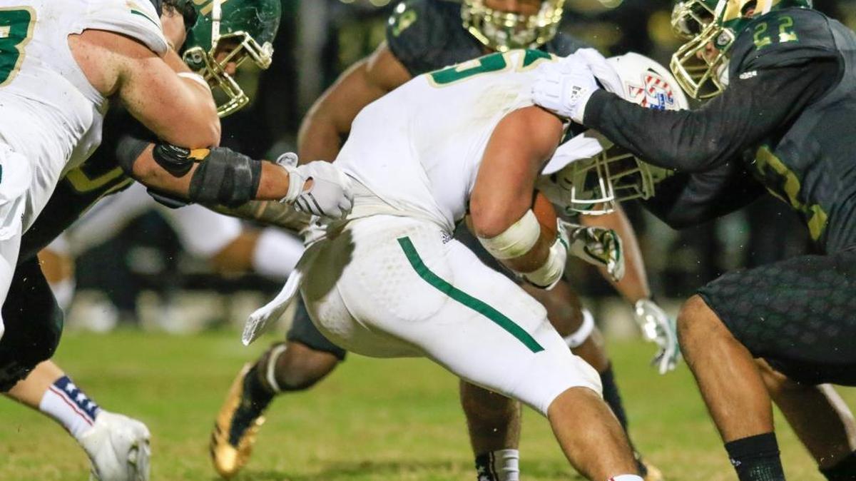 Cal Poly plays host to Sacramento State in the Mustangs' final home game of the 2017 season. Cal Poly's (35) carries the ball, but gets tackled by Sac State's Miguel Garcia (22) and Seperini Togiai Aumua (91).