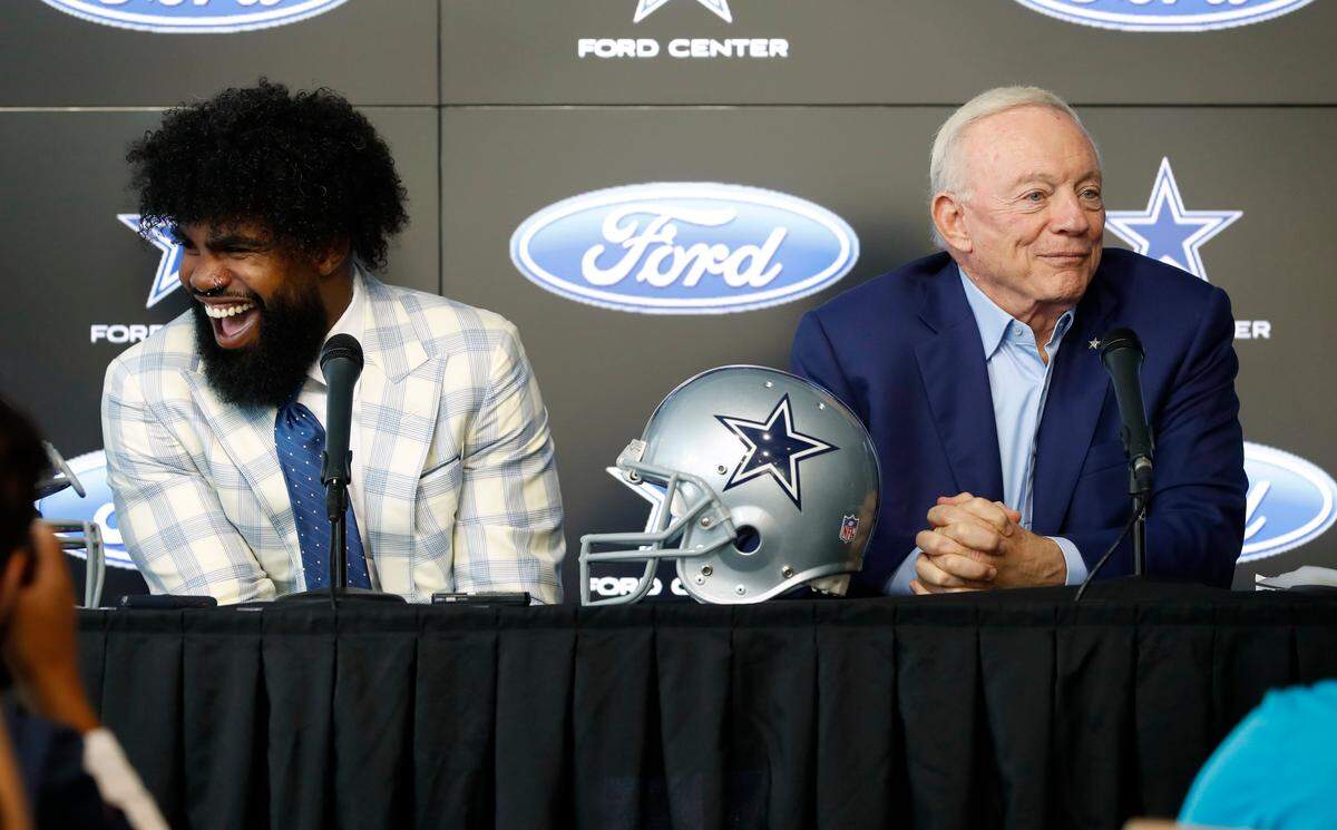 Dallas Cowboys running back Ezekiel Elliott, left, laughs after comments made by team owner Jerry Jones, right, during a news conference regarding Elliott’s new contract at the NFL football team’s practice facility in Frisco, Texas, Thursday, Sept. 5, 2019.