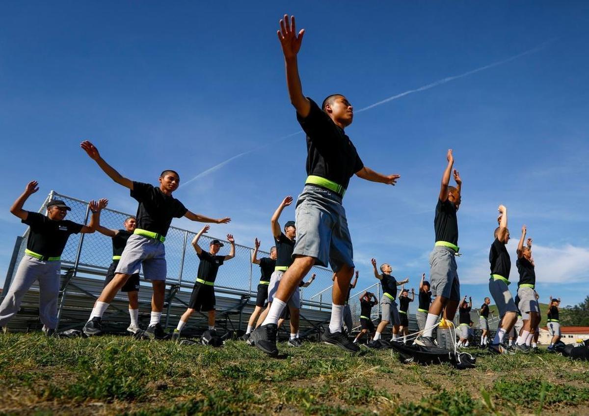 In a 2017 file photo, cadets at the Grizzly Youth Academy warm up before their twice-weekly run club. An outbreak of COVID-19 has forced the program to send its entire current class home.