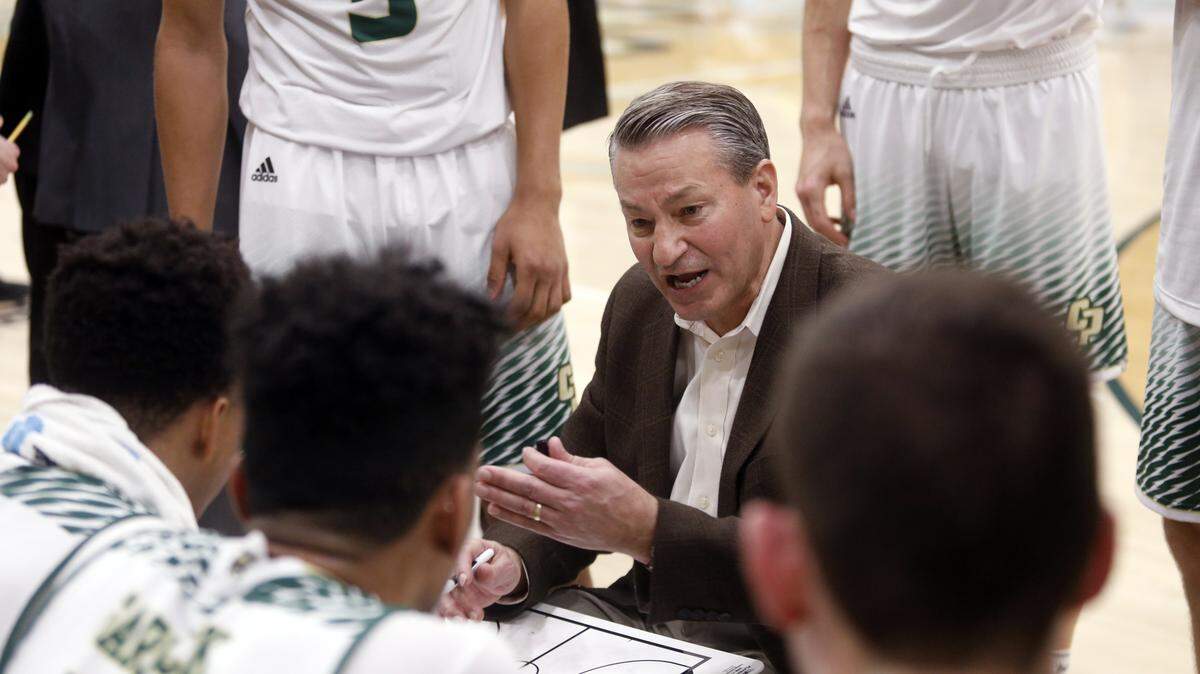 Cal Poly head basketball coach Joe Callero huddles with his team in the 2017-2018 season.